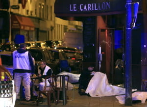 Victims lay on the pavement in a Paris restaurant, Friday, Nov. 13, 2015. Police officials in France on Friday reported a shootout in a Paris restaurant and an explosion in a bar near a Paris stadium. It was unclear if the events were linked. (AP Photo/Thibault Camus) ORG XMIT: PAR108